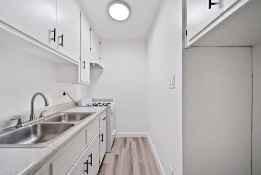 A kitchen with a sink and a stove top.