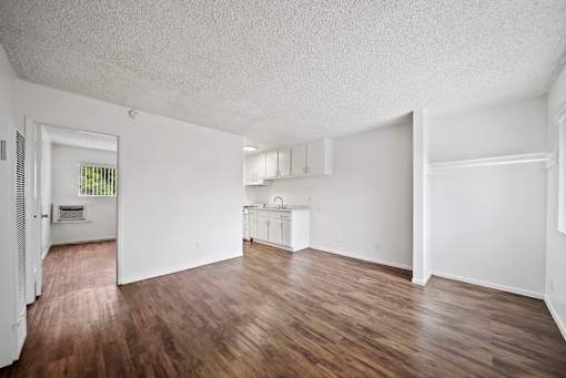 A large empty room with wooden floors and white walls.