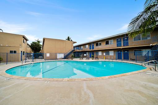 A large outdoor swimming pool surrounded by a fence.