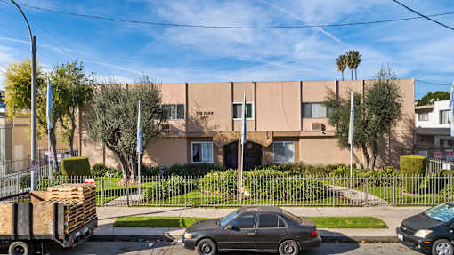 A beige building with a black car parked in front of it.