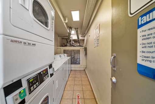 A laundry room with a washing machine and a sign on the door.