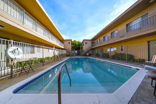 A small pool in a courtyard surrounded by buildings.