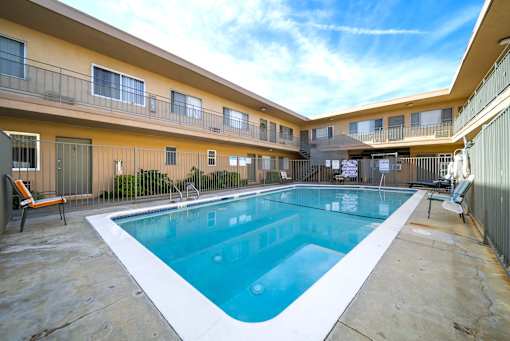 A swimming pool in a courtyard surrounded by buildings.