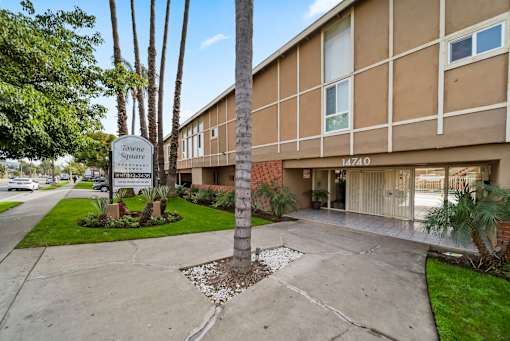 A building with a sign that says "Torrance Square" in front of it.