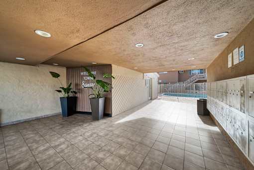 A hallway with a sign that says "Well we town" and a plant in a pot.