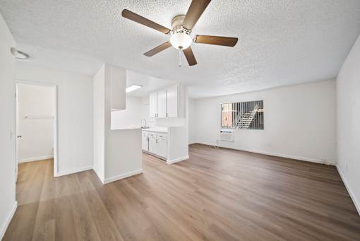 A room with a ceiling fan and wooden flooring.