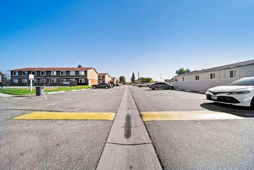 A white car is parked on the right side of a street.
