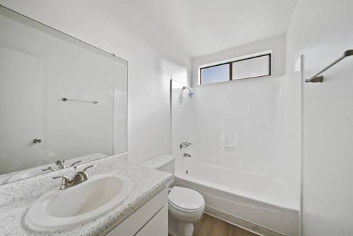 A white bathroom with a sink, toilet, and bathtub.