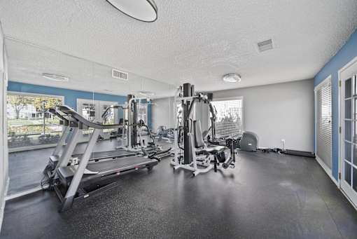 A spacious gym with treadmills, elliptical machines, and other exercise equipment.