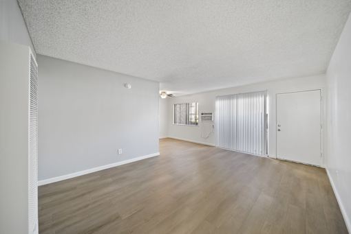 A room with wooden flooring and white walls.