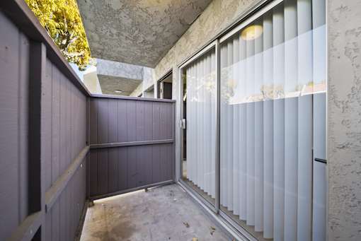 A room with a concrete wall and a glass door.