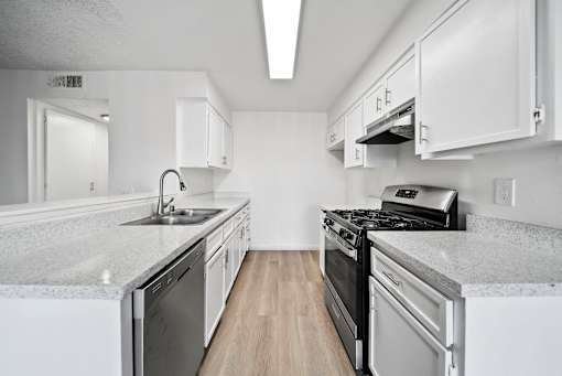 A kitchen with white cabinets and a black stove top oven.