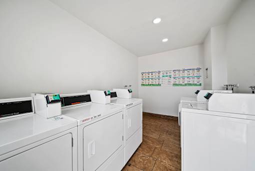 A laundry room with a washer and dryer on the left and a sink on the right.