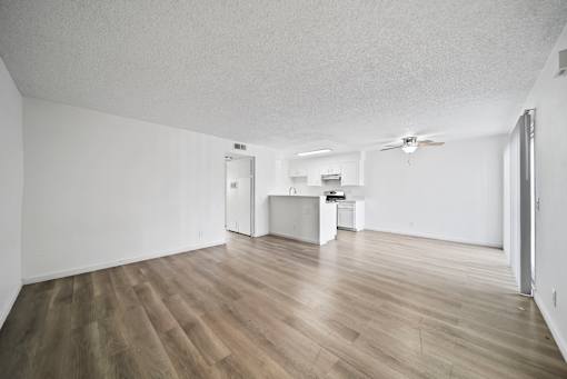 A room with wooden flooring and a ceiling fan.