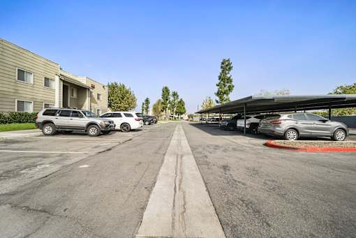 A parking lot with cars parked and a building in the background.