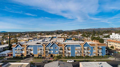 Apartment complex with blue and beige buildings under a clear sky.