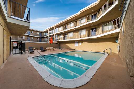 A small pool in a courtyard surrounded by buildings.