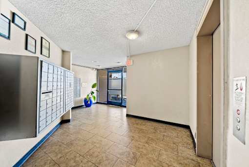 A hallway with a blue vase and a fridge on the left.