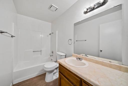 A white toilet sits next to a sink in a bathroom.