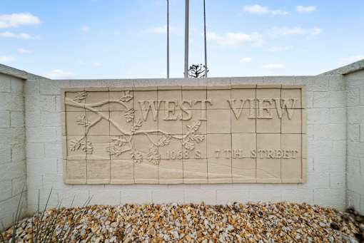 A stone plaque on a wall that says West View.