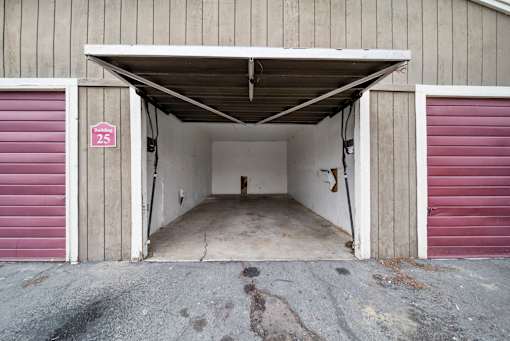 A garage with a red door and a sign that says 25.