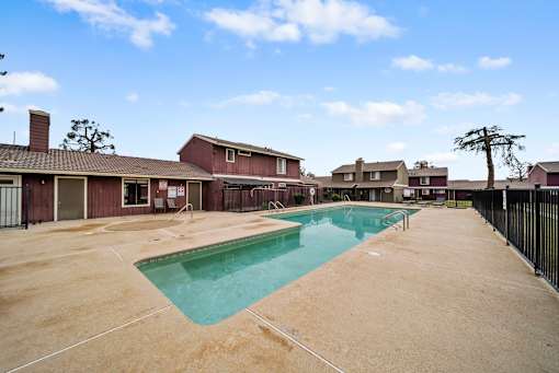 A swimming pool in a residential area surrounded by houses.
