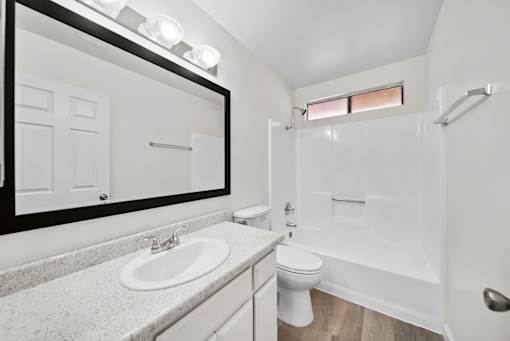 A white bathroom with a sink, toilet, and bathtub.
