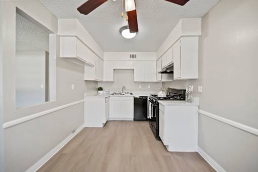 A kitchen with white cabinets and a black stove top oven.