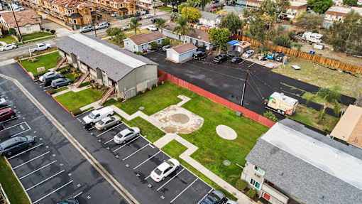 A parking lot with cars and a building in the background.