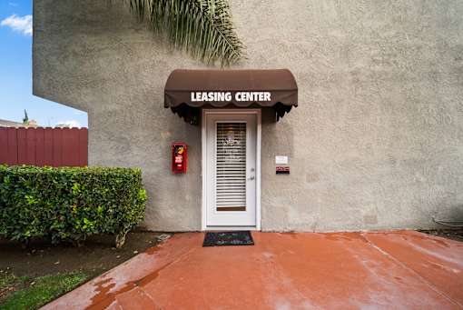 A leasing center with a white door and a red fire extinguisher on the wall.