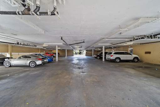 A parking garage with a white car in the foreground.