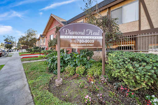 A sign for Diamond Head Apartment Homes stands in front of a building.
