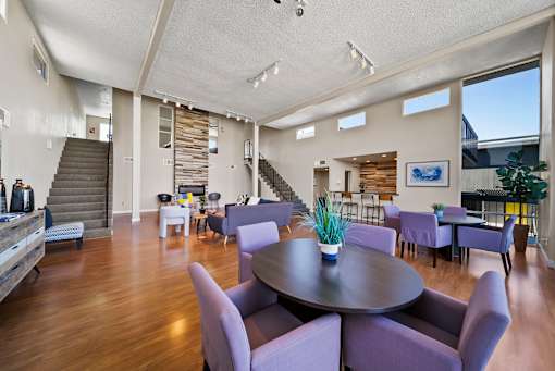 A large room with a round table and purple chairs.