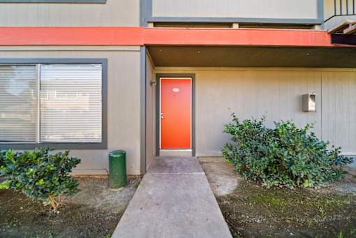 A red door is on the side of a building.