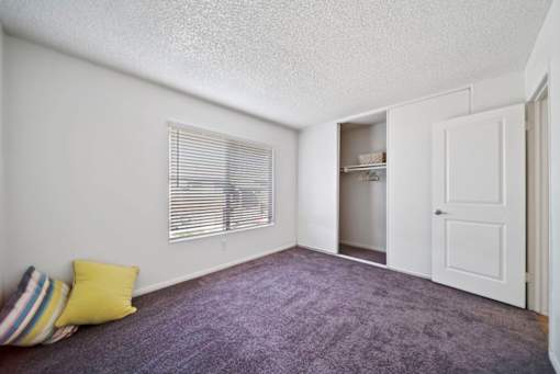 A room with a purple carpet and a white door.