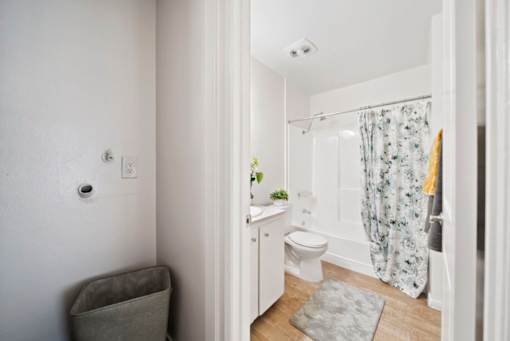 A white bathroom with a toilet, sink, and shower.