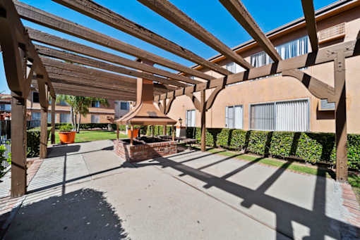 A wooden pergola over a walkway in a residential area.