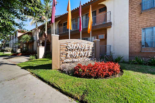 The sign in front of the building says Sunset Pointe Apartment Homes.