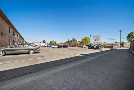 A parking lot with a car and a building in the background.