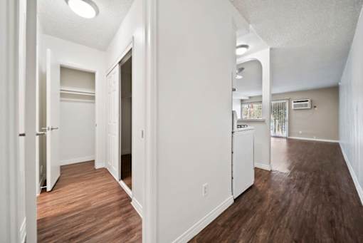 A long hallway with white walls and wood floors.