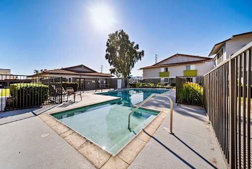 A sunny day at a pool with a fence on the right.
