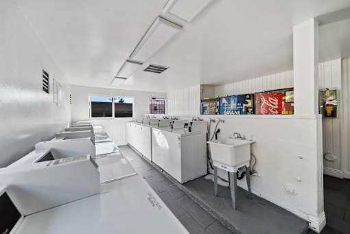 A row of white sinks are lined up in a room.