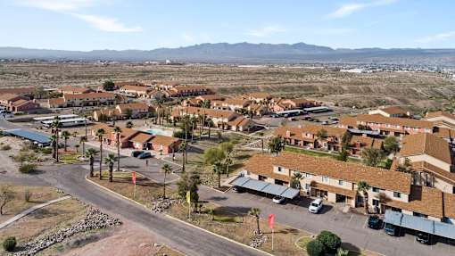 A large apartment complex with a parking lot in front.