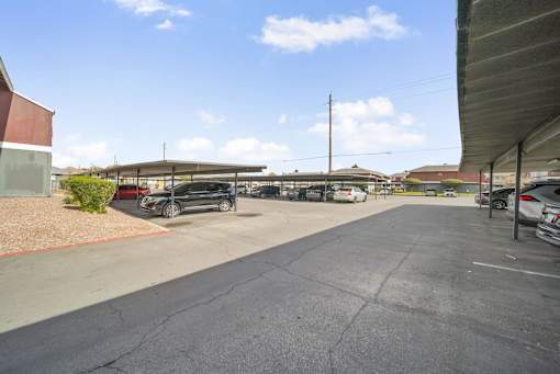 A parking lot with cars and a building on the left.