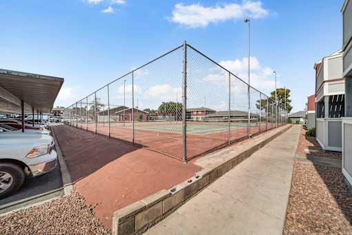 A tennis court is enclosed by a chain-link fence.