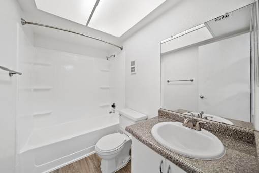 A white bathroom with a toilet, sink, and bathtub.