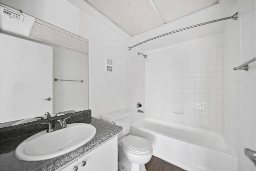 A white bathroom with a sink, toilet, and bathtub.