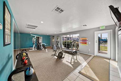 A gym with a variety of equipment including a treadmill, weights, and a bench press.