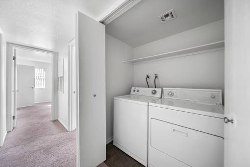 A white laundry room with a washer and dryer.