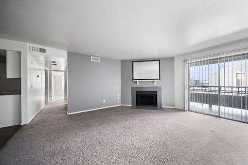 A spacious living room with a fireplace and a flat-screen TV.